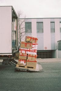 Stack of cardboard boxes on a delivery truck liftgate, illustrating cross-border e-commerce logistics and a hybrid fulfillment model.